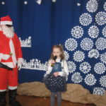 Dziewczynka śpiewa Mikołajowi piosenkę.