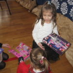 Dzieci rozpakowują prezenty.