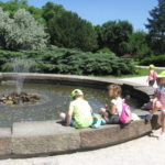 Dzieci odpoczywają obok fontanny.