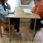 Uczniowie czytają książki w bibliotece.