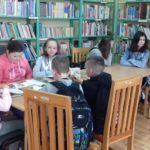 Uczniowie czytają książki w bibliotece.