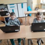 Dzieci pracują na komputerach.