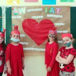 Uczniowie klasy pierwszej wykonują plakat - dziecko o wielkim sercu.
