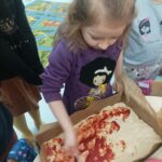 Dzieci robią pizzę.