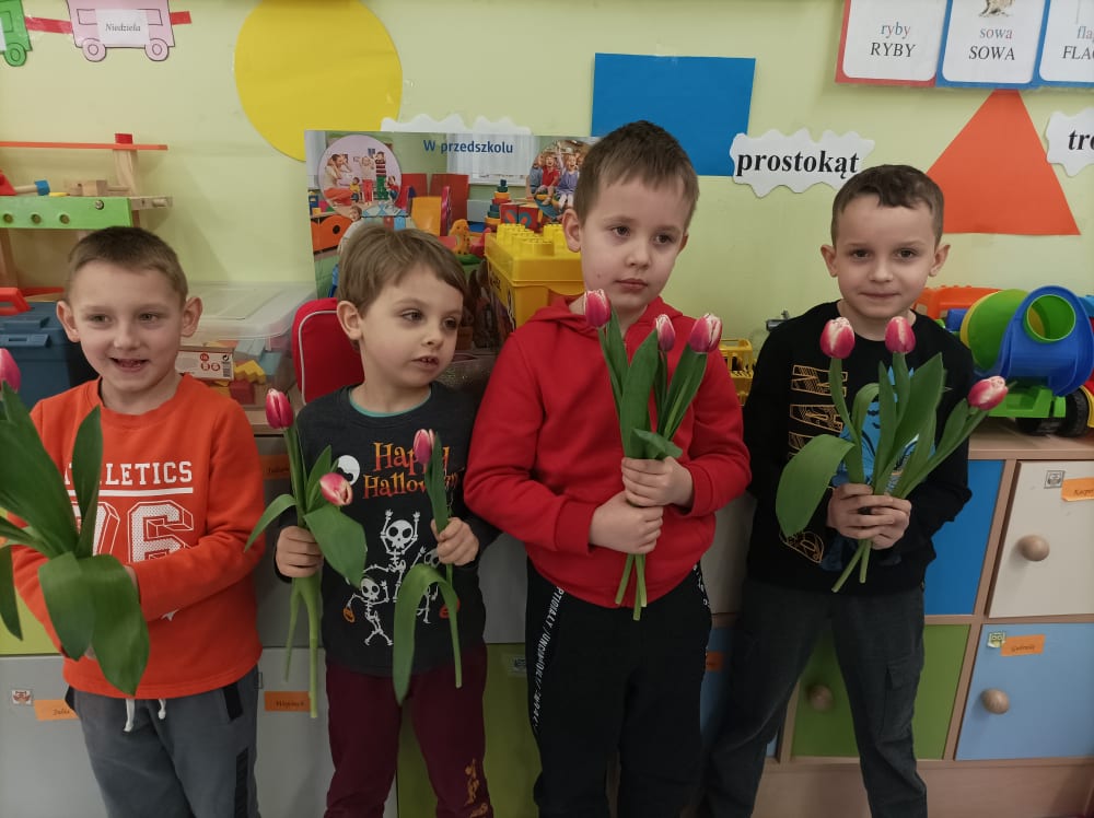 Chłopcy wręczają kwiatki.