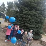 Dzieci z niebieskimi balonikami.