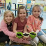 Dzieci prezentują posiane kwiatki.