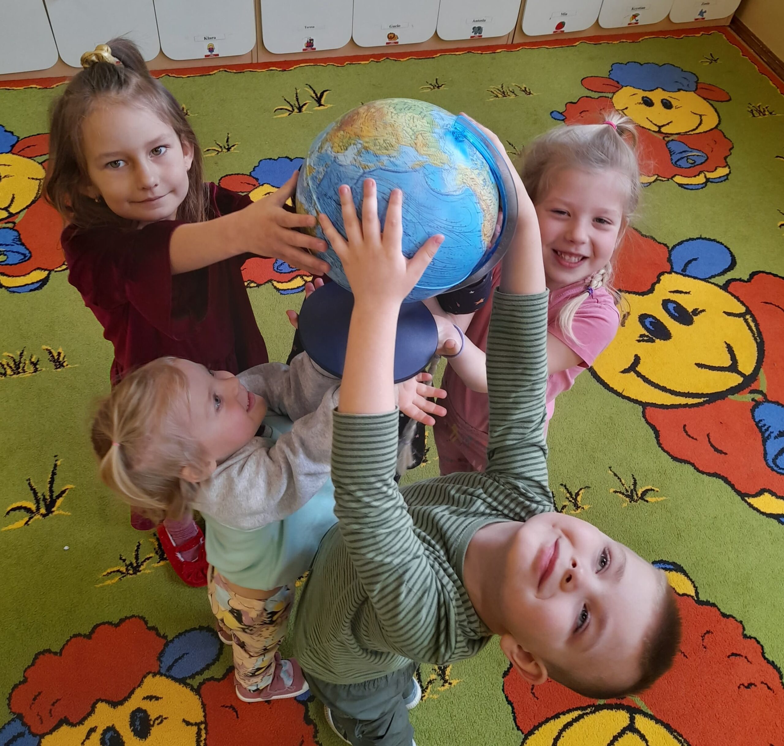 Dzieci prezentują globus.