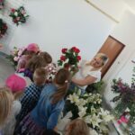 Dzieci oglądają kwiaty w kwiaciarni.