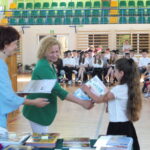 Uczennica klasy 1 odbiera nagrodę dyrektora.