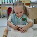 Dzieci wykonują prace ceramiczne.