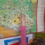 Dziecko pokazuje na mapie Warszawę.