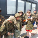 Uczniowie w mundurach, wyposażeni w sprzęt bojowy.