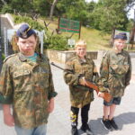 Uczniowie w mundurach, wyposażeni w sprzęt bojowy.