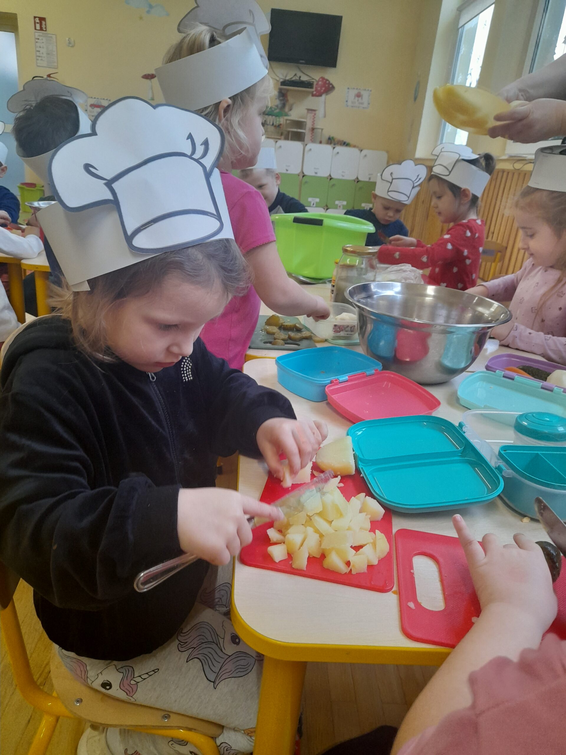 Dzieci przygotowują sałatkę.